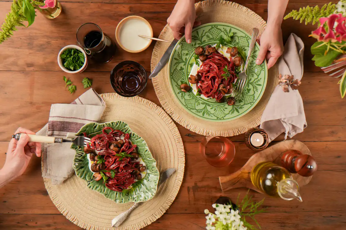 mesa montada com dois pratos e mãos