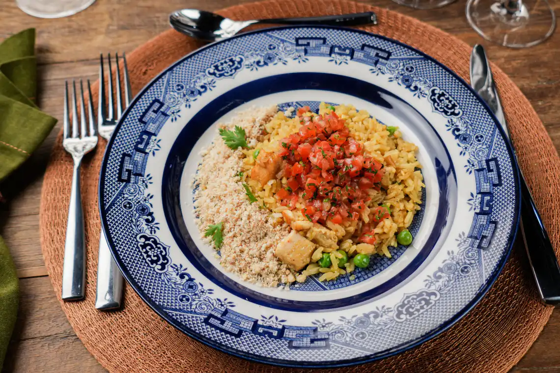 prato montado com galinhada, saladinha de tomate e farofa de castanha-de-caju com salsinha