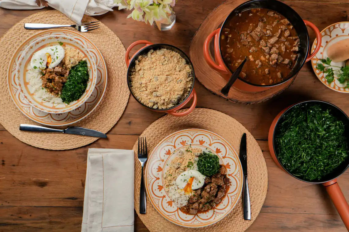 mesa montada (dois pratos, panela com picadinho, frigideira couve)
